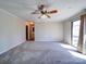 A spacious living room featuring neutral carpet, a ceiling fan, and a view into the hall at 4401 Coachwood Ln, Gastonia, NC 28056