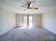 Neutral carpet living room with ceiling fan and sliding glass door, offering an airy feel at 4401 Coachwood Ln, Gastonia, NC 28056