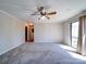 Large living room featuring neutral carpet, a ceiling fan, and a sliding door to the outside at 4401 Coachwood Ln, Gastonia, NC 28056