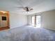 Bright living room with carpet, ceiling fan and sliding glass door with backyard view at 4401 Coachwood Ln, Gastonia, NC 28056