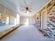 Bright sunroom featuring brick and wood paneling, plus multiple windows, a ceiling fan, and an exterior door at 4401 Coachwood Ln, Gastonia, NC 28056