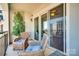 Inviting balcony with wicker chairs, offering a view of surrounding city buildings at 4620 Piedmont Row Dr # 605, Charlotte, NC 28210
