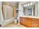 Well-lit bathroom featuring a shower-tub, vanity with wooden cabinets, and open mirror at 4620 Piedmont Row Dr # 605, Charlotte, NC 28210
