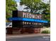Exterior view of Piedmont Town Center sign with surrounding trees and landscaping at 4620 Piedmont Row Dr # 605, Charlotte, NC 28210