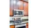 Close-up of the kitchen with a view of microwave over range, cabinetry, and granite counters at 4620 Piedmont Row Dr # 605, Charlotte, NC 28210