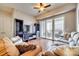 Comfortable living room with hardwood floors, a balcony overlooking the city, and built-in shelving at 4620 Piedmont Row Dr # 605, Charlotte, NC 28210