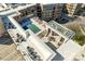 Aerial view of a rooftop pool and sundeck with lounge chairs at this luxury condo building at 4620 Piedmont Row Dr # 605, Charlotte, NC 28210