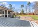 A backyard features a stone patio with a fire pit and grilling area with a playset and storage shed in the distance at 4858 Sagittarius Cir, Denver, NC 28037