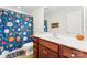 Charming bathroom featuring a wooden vanity, sink, toilet, and shower curtain with a sports theme at 4858 Sagittarius Cir, Denver, NC 28037
