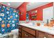 Bathroom featuring bright red walls, sport-themed decor, and wooden vanity at 4858 Sagittarius Cir, Denver, NC 28037