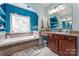 A bathroom features a soaking tub surrounded by brown tile, and a granite vanity with dark wood cabinets at 4858 Sagittarius Cir, Denver, NC 28037