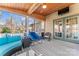 A covered porch features outdoor seating, a wood ceiling, and access to the backyard and to an exterior door at 4858 Sagittarius Cir, Denver, NC 28037
