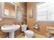 Chic powder room featuring rustic wood paneling, a pedestal sink, and stylish decor at 4858 Sagittarius Cir, Denver, NC 28037