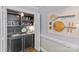 Home bar with glass shelves, sink, and a selection of glassware for entertaining at 5114 Morrowick Rd, Charlotte, NC 28226