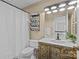 The bathroom has a marble sink with a dark wood cabinet, toilet, and white shower curtain at 5114 Morrowick Rd, Charlotte, NC 28226