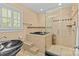 A well-lit bathroom showcasing a black soaking tub, glass shower, and black vessel sink at 5114 Morrowick Rd, Charlotte, NC 28226