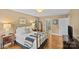 A bedroom with hardwood floors, gold bed frame, side tables with lamps, and lots of natural light at 5114 Morrowick Rd, Charlotte, NC 28226