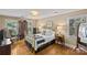Bright bedroom with a brass bed frame, natural light, hardwood floors, and elegant furnishings at 5114 Morrowick Rd, Charlotte, NC 28226