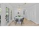 Bright breakfast nook with white table, four chairs, and view to the outdoors through french doors at 5114 Morrowick Rd, Charlotte, NC 28226