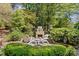Charming stone outdoor fireplace with Adirondack chairs creating a cozy backyard retreat at 5114 Morrowick Rd, Charlotte, NC 28226
