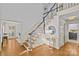 Elegant foyer with hardwood floors, staircase, white trim, and decorative table with round mirror at 5114 Morrowick Rd, Charlotte, NC 28226