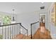 Upstairs hallway featuring hardwood floors and natural light from a large window at the landing at 5114 Morrowick Rd, Charlotte, NC 28226
