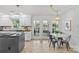 Open kitchen with granite countertops, island, white cabinets, stainless appliances, and adjacent breakfast nook at 5114 Morrowick Rd, Charlotte, NC 28226