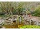 View of a beautiful backyard garden with a charming pond and tranquil waterfall feature at 5114 Morrowick Rd, Charlotte, NC 28226