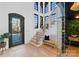 Bright entryway with dark-framed windows, a wooden staircase, and a glass-encased wine storage for a modern touch at 680 Ideal Way, Charlotte, NC 28203