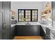 Modern kitchen with dark cabinets, marble countertops, stainless steel appliances, and floating shelves at 680 Ideal Way, Charlotte, NC 28203