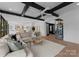 Open-concept living room featuring black beams, hardwood floors, and a stylish wine rack at 680 Ideal Way, Charlotte, NC 28203