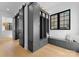 Bright mudroom boasts storage lockers, bench seating, wood floors, and black framed windows for a classic modern touch at 680 Ideal Way, Charlotte, NC 28203