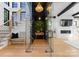 Modern wine room features glass enclosure, showcasing wine collection; the space includes a staircase, bench seating, and greenery at 680 Ideal Way, Charlotte, NC 28203