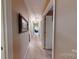 Hallway leading to another room with a visible light fixture, neutral colored walls, and carpet at 7327 Carrbridge Ln, Charlotte, NC 28226