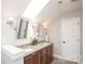 Bathroom with double sink vanity, granite counters, modern lighting, and a skylight providing ample natural light at 7343 Rock Island Rd, Charlotte, NC 28278