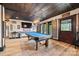 Basement features a billiards table, tv, bar stools, and wooden sliding barn doors at 8014 Kiwi Pt, Tega Cay, SC 29708