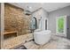 Luxurious bathroom featuring a stone accent wall in the shower, a modern tub, and elegant fixtures at 8014 Kiwi Pt, Tega Cay, SC 29708