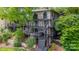 Multi-level home with multiple decks and stairs, set among mature trees and landscaping at 8014 Kiwi Pt, Tega Cay, SC 29708