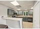 Modern kitchen with stainless steel appliances, gray cabinets, stylish tile backsplash, and breakfast bar at 8014 Kiwi Pt, Tega Cay, SC 29708