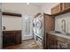 Functional laundry room featuring a modern washer and dryer unit, sink, and rustic wooden cabinetry at 8014 Kiwi Pt, Tega Cay, SC 29708