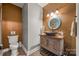 Stylish powder room featuring a vessel sink, unique mirror, and decorative wall accents at 8014 Kiwi Pt, Tega Cay, SC 29708