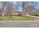 A street view of a tan and brick house, complete with mature trees and well-kept lawn at 809 E 23Rd Street St, Newton, NC 28658
