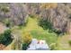 Aerial view of a spacious backyard with lush greenery, mature trees, and a cozy patio area at 8201 Tonawanda Dr, Charlotte, NC 28277