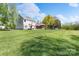 Large grassy backyard featuring the home's exterior, patio, and mature trees, offering space for outdoor activities at 8201 Tonawanda Dr, Charlotte, NC 28277