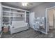 Inviting home office with custom built-in shelving, a comfortable sofa, and a functional desk area at 8201 Tonawanda Dr, Charlotte, NC 28277