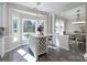 Sunlit kitchen island with breakfast bar seating, stone countertops, and an open view to the backyard at 8201 Tonawanda Dr, Charlotte, NC 28277