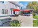 Relaxing backyard patio features stylish outdoor seating, shade umbrellas, and access to a screened-in porch at 8201 Tonawanda Dr, Charlotte, NC 28277