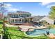 Large backyard with a swimming pool, landscaped patio, and an inviting covered outdoor space at 8511 Fox Tail Ln, Huntersville, NC 28078