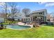 Landscaped backyard features a pool, deck, and covered patio, perfect for outdoor entertaining at 8511 Fox Tail Ln, Huntersville, NC 28078