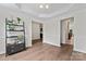 A bright living room boasts a modern shelf, wood floors, and abundant natural light from nearby rooms at 8511 Fox Tail Ln, Huntersville, NC 28078